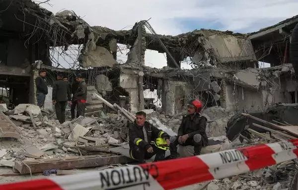 A civil defense team carries out search and rescue operations in a damaged building following a missile strike launched by Iran's Islamic Revolutionary Guard Corps (IRGC) on Erbil, capital of Iraq's Kurdish region, on January 17. [Safin Hamid/AFP]