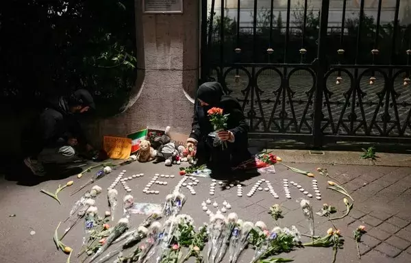 A woman holds flowers during a gathering in front of the Iranian Embassy in Paris on January 4, in tribute to victims of ISIS-claimed twin bombings in Kerman the day before that killed at least 84 people and injured hundreds of others. [Dimitar Dilkoff/AFP]