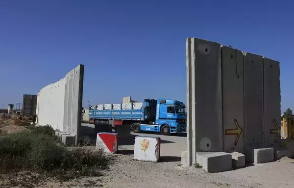 A truck carrying humanitarian aid drives at the Israeli side of the Kerem Shalom border crossing to undergo security checks before entering the southern Gaza strip, on January 22. [Menahem Kahana/AFP]