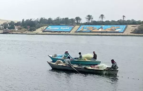 Fishermen sit in boats in the Suez Canal near Ismailia in eastern Egypt on January 9, 2023. [AFP]