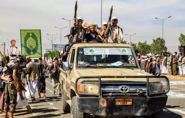 Houthis elements armed with rocket-propelled grenade (RPG) launchers and assault rifles ride in the back of a pickup vehicle parading in Sanaa on February 7. [Mohammed Huwais/AFP]