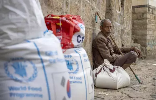 Displaced Yemenis receive aid provided by the UN's World Food Program in the city of Taez on September 11. [Ahmad al-Basha/AFP]