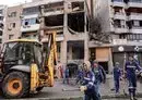 
Municipal workers on January 3 clean the street in front of a building in Beirut's southern suburb where Hamas deputy leader Saleh al-Aruri was killed in a drone strike the day before. [Anwar Amro/AFP]        