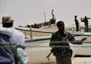 
Armed militiamen and some pirates stand among fishing boats on the coast in the central Somali town of Hobyo on August 20, 2010. [Roberto Schmidt/AFP]        