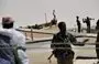 
Armed militiamen and some pirates stand among fishing boats on the coast in the central Somali town of Hobyo on August 20, 2010. [Roberto Schmidt/AFP]        