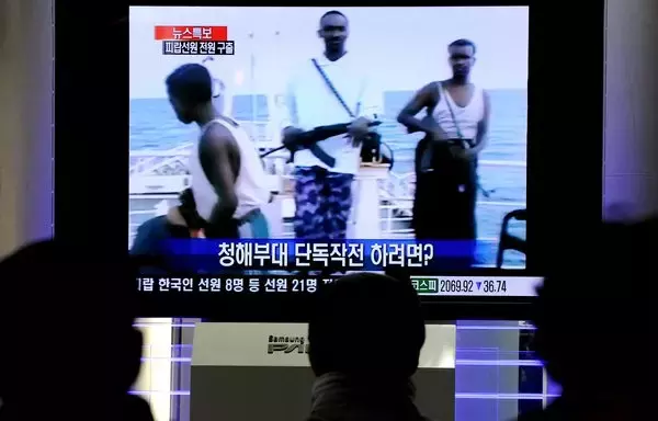 South Koreans watch a South Korean navy military operation against Somali pirates in the Indian Ocean in Seoul on TV January 21, 2011. [Park Ji-Hwan/AFP]