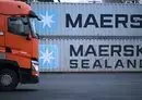 
A truck driver makes his way past containers with the logo of Danish shipping giant Maersk and Maersk Sealand stacked at a transshipment station in western Germany, on January 23. [Kirill Kudryavtsev/AFP]        