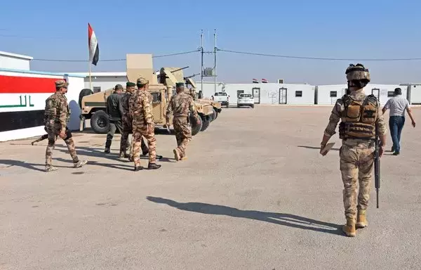 Iraqi forces walk on the Iraqi side of the border crossing between al-Qaim in Iraq and Albu Kamal in Syria on September 30, 2019. [Moadh al-Dulaimi/AFP]