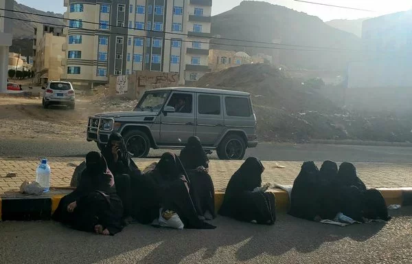 Yemeni women beg beside the road in Sanaa's Bayt Baws neighborhood. [Yazan Abdul Aziz/Al-Fassel]