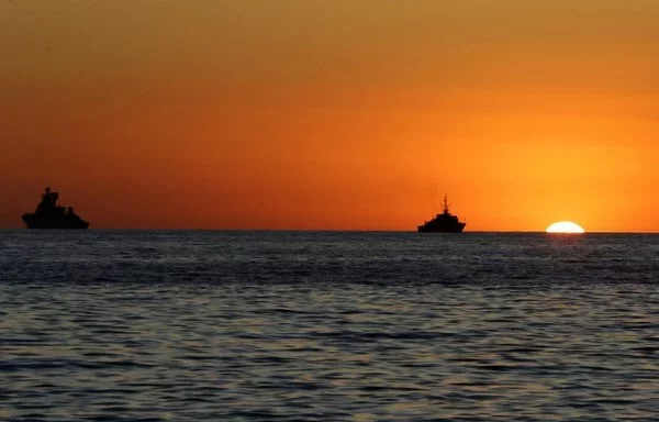 Vessels are moored in the Mediterranean sea at sunset, off the coast of the Syrian port city of Tartous, on July 24, 2022. [Louai Beshara/AFP]