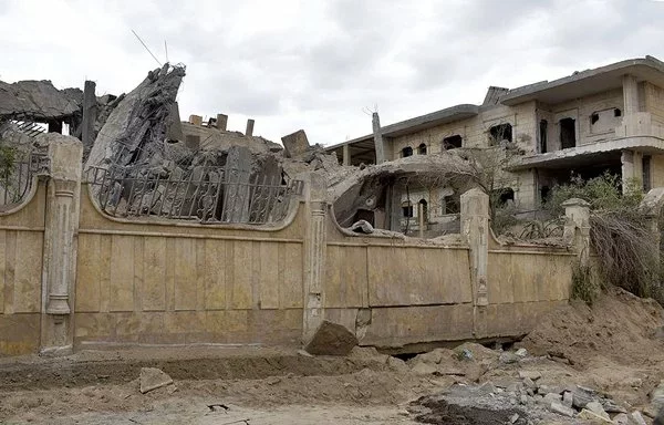 A photo taken March 26 shows a view of a damaged building following an air strike in Syria's eastern city of Deir Ezzor that killed at least nine pro-Iran fighters, including an IRGC commander, and four others, the Syrian Observatory for Human Rights said. [AFP]