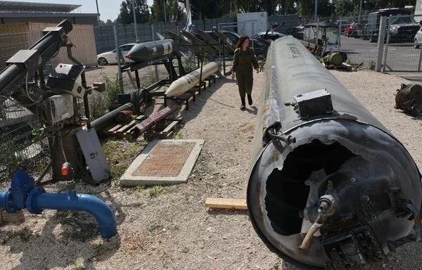 A member of the Israeli military walks past an Iranian ballistic missile that fell in Israel over the weekend, during a media tour at the Julis military base near the southern Israeli city of Kiryat Malachi on April 16. [Gil Cohen-Magen/AFP]