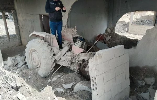 A resident of Tayr Harfa inspects the remains of his house. [Al-Fassel]