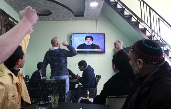 Palestinians watch Hizbullah chief Hassan Nasrallah give a televised speech from an undisclosed location in Lebanon on Hizbullah's Al-Manar TV on January 30, 2015. [Hazem Bader/AFP]