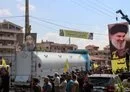
Hizbullah supporters raise the party's flag and photos of Hizbullah chief Hassan Nasrallah, as tankers enter the Lebanese city of Baalbek carrying Iranian fuel from Syria, in defiance of sanctions, on September 16, 2021. [AFP]        