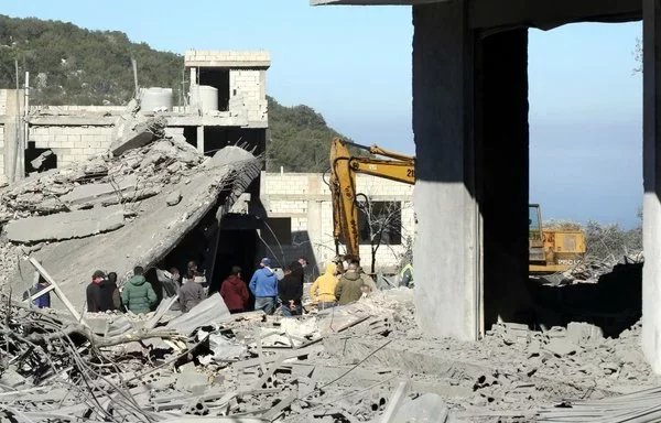 Residents and rescuers check destruction in the southern Lebanese village of Kafra, on February 29, amid cross-border tensions between Israel and Hizbullah. [Mahmoud Zayyat/AFP]