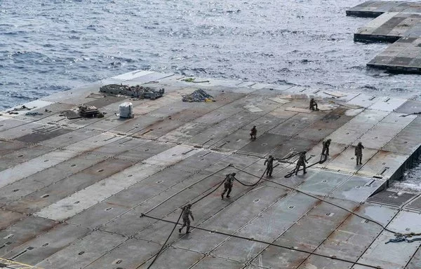 US Army soldiers handle line to secure the floating pier to the side of the MV Roy P. Benavidez off the coast of Gaza on May 1. Aid began to flow into Gaza via the temporary pier on May 17. [US Navy]