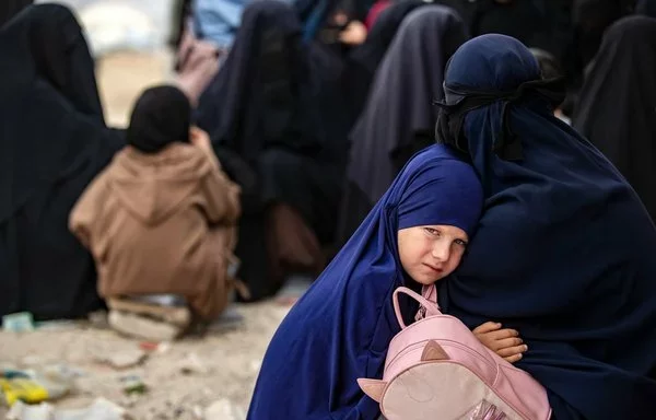 A girl hugs her mother at al-Hol camp in Syria in 2023. [Delil Souleiman/AFP]