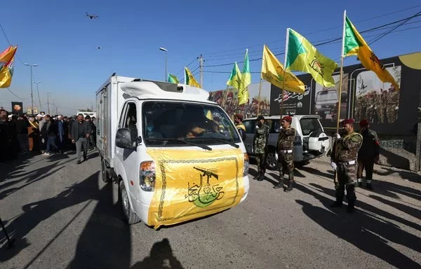 صورة التقطت خلال مراسم تشييع في بغداد يوم 4 كانون الأول/ديسمبر 2023 تظهر علما ميليشيا حركة النجباء وكتائب حزب الله العراقيتين. [أحمد الربيعي/وكالة الصحافة الفرنسية]