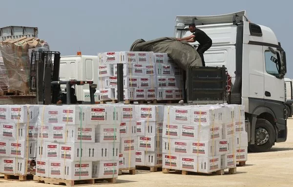 Workers unload aid from a truck in Gaza in early May. [Jack Guez/AFP]