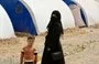 
A woman and child stand near tents at al-Jadaa camp in Iraq, which houses families repatriated from Syria's al-Hol camp, on April 29. Families undergo psychological rehabilitation at al-Jadaa. [Zaid al-Obeidi/AFP]        