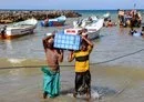 
Fishermen unload their catch upon reaching shore in Yemen's al-Khokha district, south of al-Hodeidah on April 21. [Khaled Ziad/AFP]        