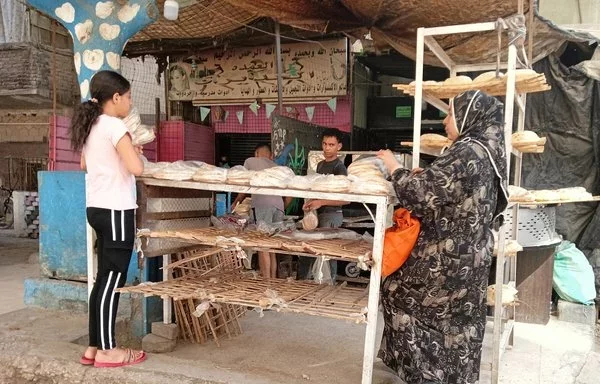 A mother and daughter shop for bread at a bakery in Cairo. [Jana al-Masry/Al-Fassel]