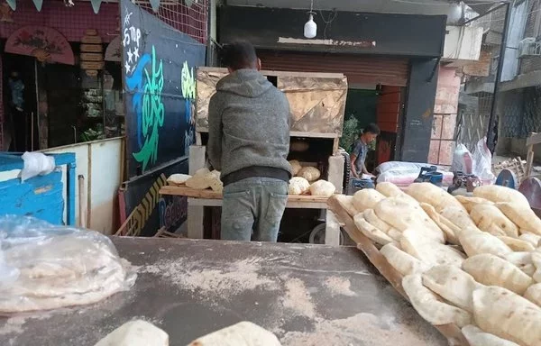 Fresh bread is taken out of the oven at a popular bakery in Cairo. [Jana al-Masry/Al-Fassel]