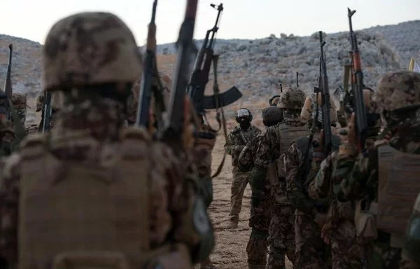 Tahrir al-Sham fighters take part in a military training graduation ceremony in Idlib province on August 16, 2023. [Omar Haj Kadour/AFP]