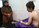 
Lebanese schoolboy Qassem Jaffal receives treatment as his teacher looks on at the Nabatieh General Hospital, following an Israeli strike that killed a Hizbullah fighter on May 23. [Mahmoud Zayyat/AFP]        