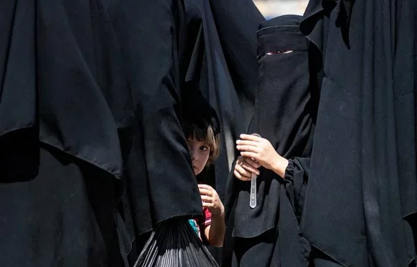 Syrian families wait inside al-Hol camp in al-Hasakeh province, which holds relatives of ISIS fighters, before being released on July 15, 2021. ISIS has attempted to recruit children from the camp. [Delil Souleiman/AFP]