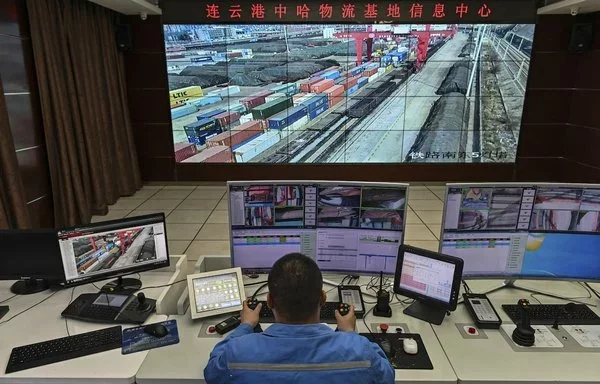 A worker operates a crane from a remote station at the Lianyungang Port Container Terminal, Jiangsu province, China, on March 24, 2021. [Hector Retamal/AFP]