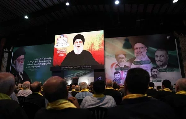 In Beirut's southern suburb, supporters watch Hizbullah chief Hassan Nasrallah deliver a televised speech on May 24. [Anwar Amro/AFP]