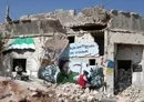 
A mural being painted on a ruined house in the Syrian town of Binnish, in Idlib province, on August 25, 2023, denounces Russia's actions in Syria and Ukraine. [Omar Haj Kadour/AFP]        