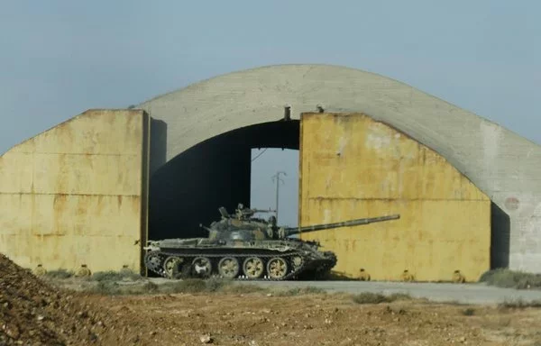 A Syrian tank is seen outside Dabaa military airport in Homs province June 7, 2013. [STR/AFP]