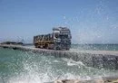 
A truck transports aid into Gaza via a US-constructed temporary pier. [CENTCOM]        