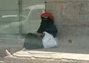 
A woman sits on a sidewalk in Houthi-controlled Sanaa. [Yazan Abdul Aziz/Al-Fassel]        