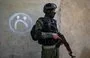 
A member of the Syrian Kurdish internal security forces (Asayesh) walks past a house during a raid against suspected ISIS fighters in al-Raqa, the group's former 'capital' in Syria, on January 29, 2023. [Delil Souleiman/AFP]        