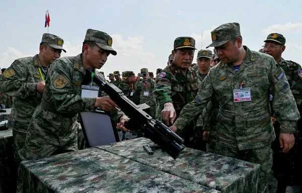 Cambodian military commander-in-chief Vong Pisen (center) and Chinese People's Liberation Army (PLA) Southern Theater Command's Vice Admiral Gao Xiucheng (right) inspect a gun at a military police base in Kampong Chhnang province, Cambodia, on May 16. [Tang Chhin Sothy/AFP]