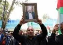 
A man holds a portrait of killed Hamas chief Ismail Haniyeh during a rally at Tehran University on July 31. [AFP]        