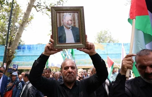 A man holds a portrait of killed Hamas chief Ismail Haniyeh during a rally at Tehran University on July 31. [AFP]