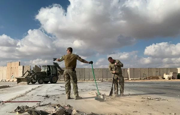 Two US soldiers clear rubble at Ain al-Asad air base in western Iraq on January 13, 2020, days after an Iran attack on the base. [Ayman Henna/AFP]