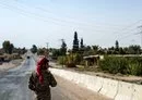 
A member of the Syrian Democratic Forces (SDF) stands guard amid a curfew in al-Busayrah, Deir Ezzor, last September 4 following clashes between the SDF and tribal fighters. [Delil Souleiman/AFP]        