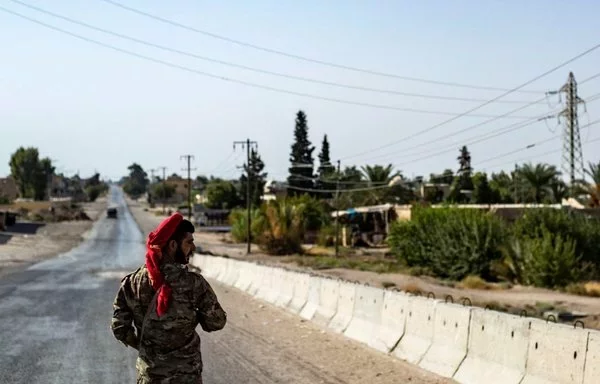 عدد من أفراد قوات سوريا الديموقراطية يؤمنون الحراسة وسط حظر للتجول في البصيرة بدير الزور في 4 أيلول/سبتمبر الماضي عقب اشتباكات بين هذه القوات ومقاتلي العشائر. [دليل سليمان/وكالة الصحافة الفرنسية]