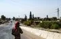 
A member of the Syrian Democratic Forces (SDF) stands guard amid a curfew in al-Busayrah, Deir Ezzor, last September 4 following clashes between the SDF and tribal fighters. [Delil Souleiman/AFP]        