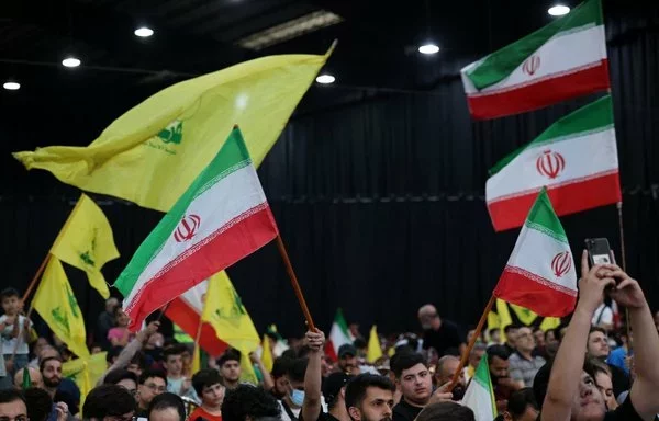 People wave Iranian and Hizbullah flags during a rally to mourn the death of Iranian President Ebrahim Raisi, in Beirut's southern suburb on May 24. [Anwar Amro/AFP]