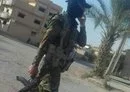 
An armed member of an IRGC-affiliated militia walks through a Deir Ezzor province border town. [File]        