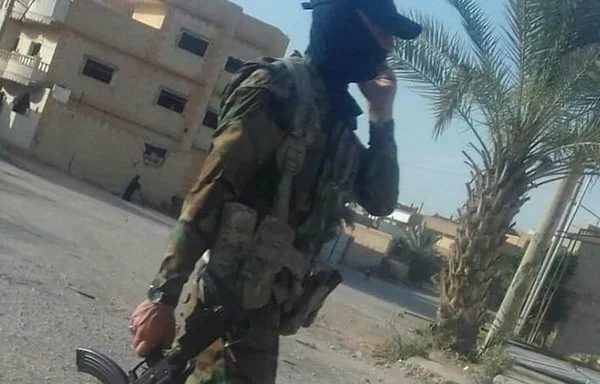 An armed member of an IRGC-affiliated militia walks through a Deir Ezzor province border town. [File]