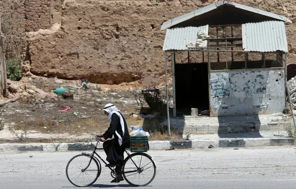 A Syrian rides his bicycle on August 1, 2013, in al-Qusayr in Syria's Homs province. [Joseph Eid/AFP]