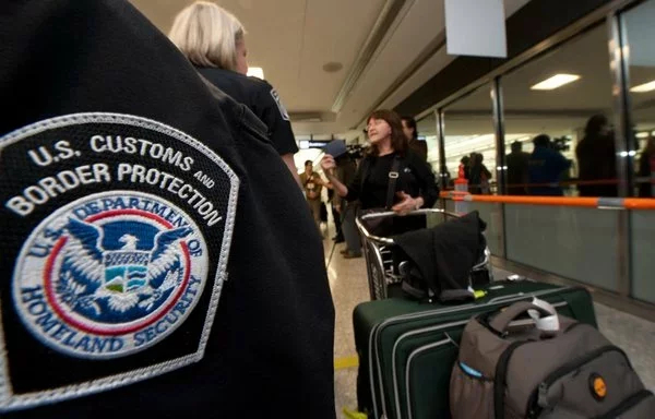 An international air traveler presents her declarations to a US Customs and Border Protection Officer in this photo from December 21, 2011. [Paul J. Richards/AFP]